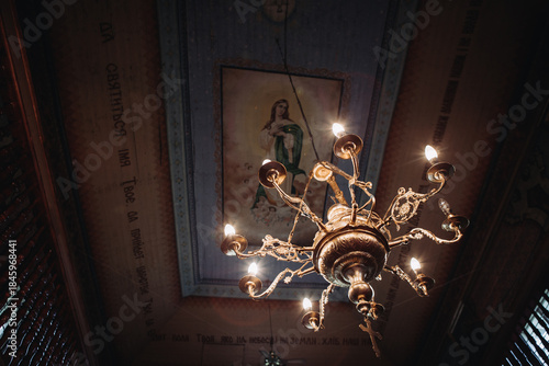 Ornate chandelier illuminating orthodox church ceiling painting