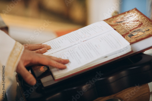 Priest reading scripture during church baptism ceremony