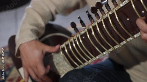 CloseUp Sitar Hands Plucking Strings In Intimate Home Studio, Session Musician Practicing Raga Phrases On Ornate Instrument, Warm Natural