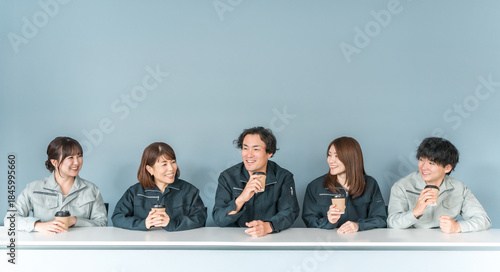 Foto A man and woman in work clothes drinking coffee in an office break room