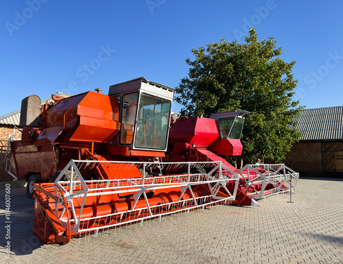 Red combine harvester parked on farm, preparing harvest