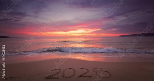 Sunset on the beach shore and sea horizon and text Happy New Year 2026 on the sand
