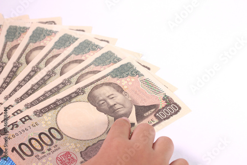 1万円札を指差す子どもの手