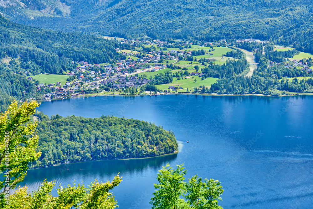 Fototapeta premium Long distance view of the village of Obertraun which sites beside the banks of the Hallstatt Lake, the town lies in the Salzkammergut region, Upper Austria, Europe 