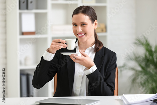 Young businesswoman drinkin...