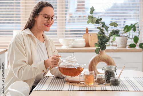 Young woman pouring tea int...