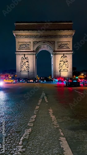 Cars drive down the street at night opposite the Arc de Triomphe, Paris, France, October 15, 2025. High quality 4k footage