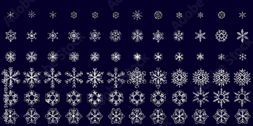 Intricate collection of diverse snowflake designs against a dark blue backdrop