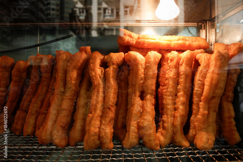 Youtiao or Chinese style fried donut or deep-fried dough stick on shelf for sell 