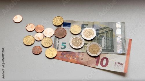 Euro coins with five and ten Euro bills on table