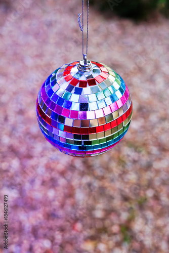 Rainbow-mirrored Disco Ball Ornament Hanging from a Tree above the Ground, Shallow DOF