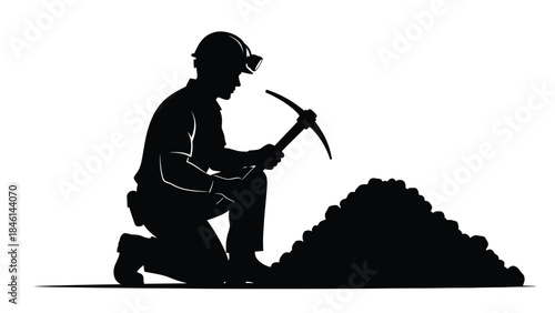Silhouette of a miner kneeling and working with a pickaxe