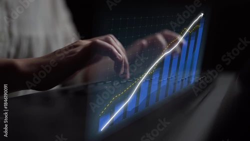 Close-up of hands typing on a keyboard with a visually stunning data graph projected above, representing growth and technology in a modern business environment. Copula