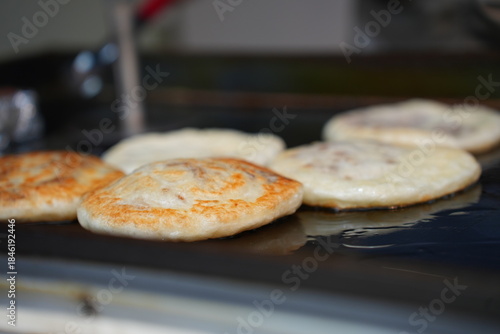 Close-up of Hotteok (Sweet Korean Pancake) Being Cooked on a Griddle