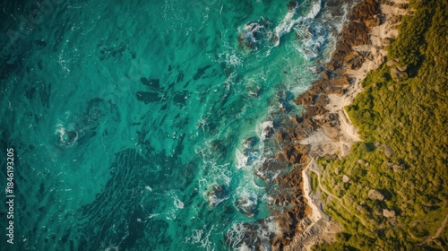 Aerial view of vibrant turquoise water meeting a rugged coastline