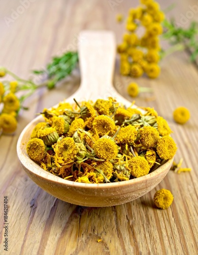 Dried Yellow Tansy Flowers in a Wooden Spoon
