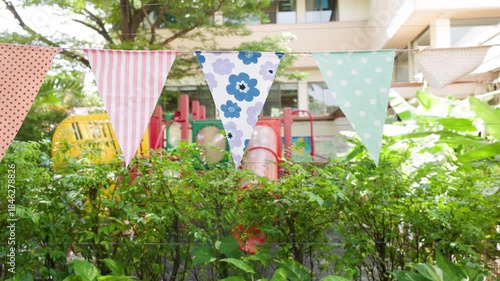 triangle flags is blowing  in garden view and playground background. garland flags among for outdoor party concept.