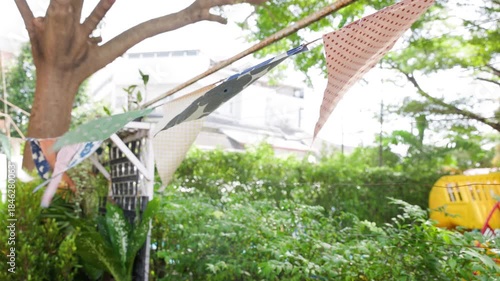 triangle flags is blowing  in garden view background. garland flags among for outdoor party concept.