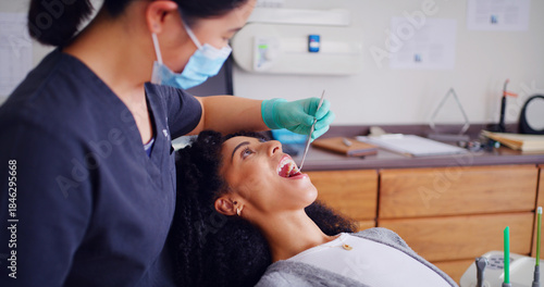 Fotografie Dentist, patient and inspection with mouth mirror for teeth assessment, oral exam and appointment in office
