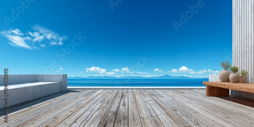 Expansive view of a wooden deck overlooking the ocean and distant mountains on a clear day with blue skies