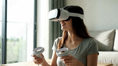 Woman using virtual reality headset and controllers in bright living room