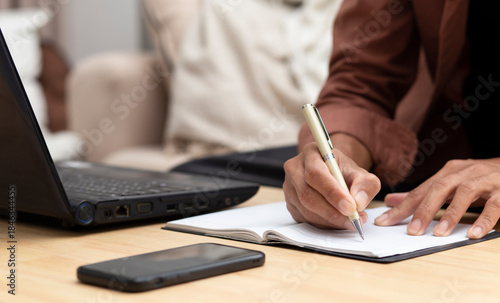 young man  writing on notebook while online learning at home, online course,  e- lerning concept