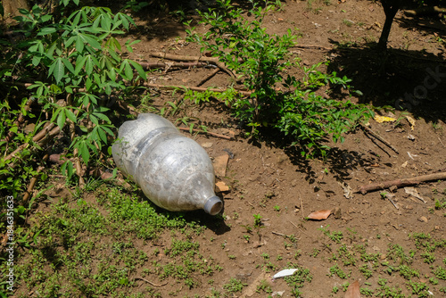 Slika na platnu Close up of used plastic drink gallons thrown away in the garden