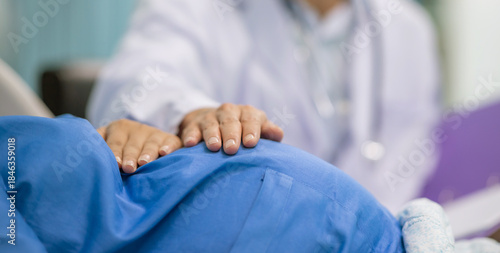 Photos Man male obstetrician doctor in white uniform coat gown with stethoscope to check womb stomach in delivery room