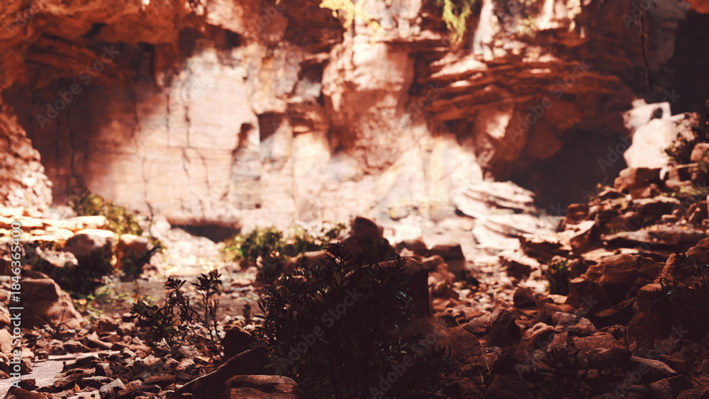 Fototapeta premium A stunning rocky landscape showcases vibrant orange and red hues, contrasting with lush green plants at the base. This scene captures the beauty of nature during the enchanting golden hour.