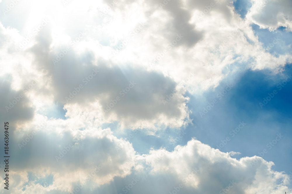 Obraz premium Bright Sun Rays in Blue Sky with Sunshine and Light Beams Through Clouds