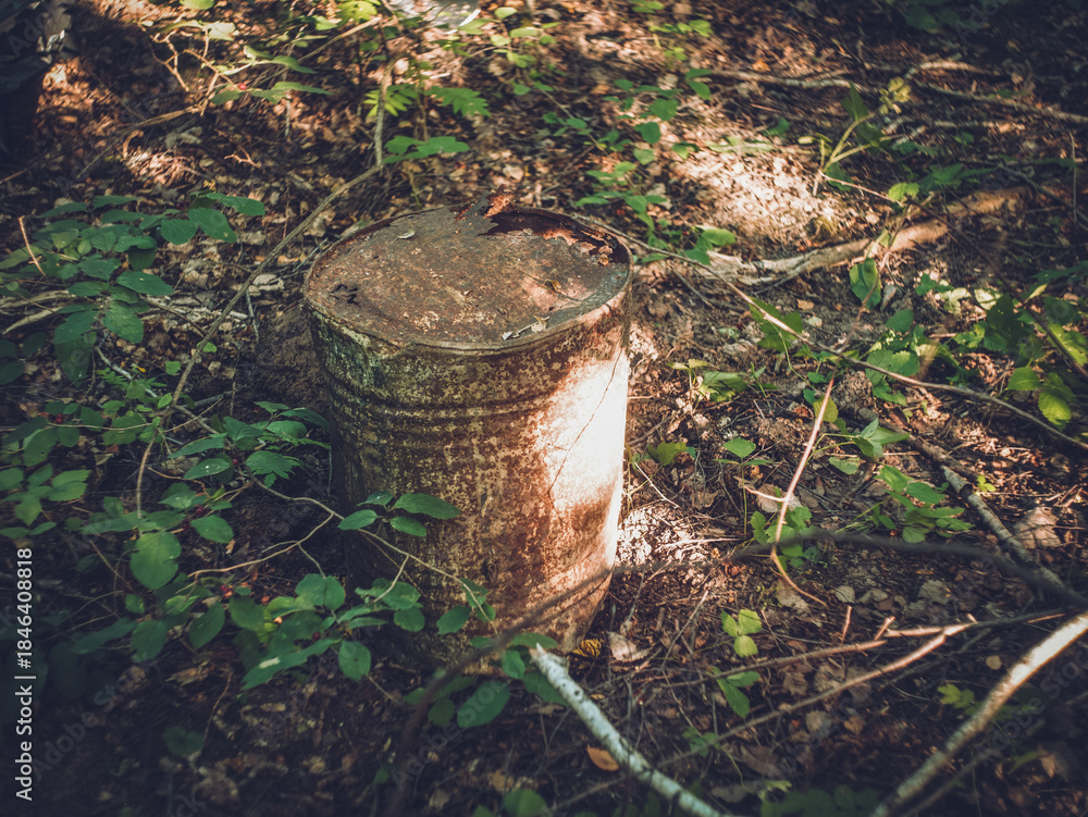 Fototapeta premium Old metal barrel in the forest