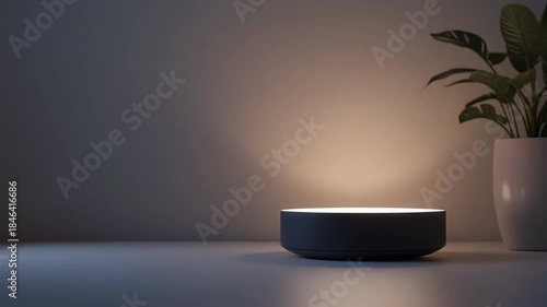 Minimalist circular smart device emitting warm light on a white table next to a potted plant, illustrating modern smart home technology.