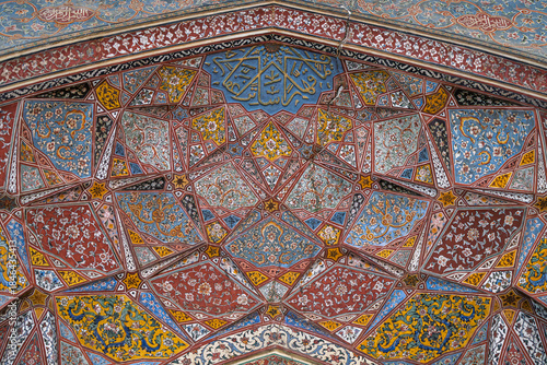 Low angle view of floral and geometric painting on archway of ancient mughal era Wazir Khan mosque entrance, Lahore, Punjab, Pakistan