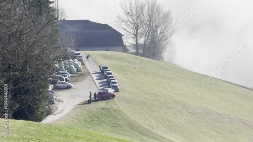 parking cars with sunseeking people fleeing foggy valley