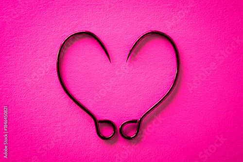 Heart-Shaped Barbless Fishing Hooks on Pink Background