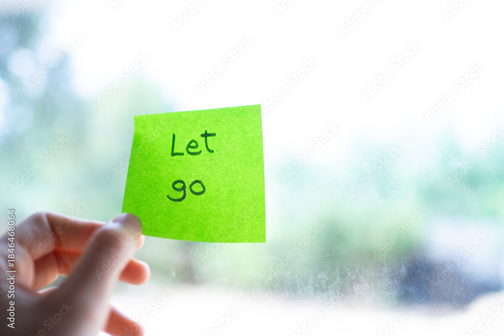 Ταπετσαρία Hand holding green sticky note with let go written on it