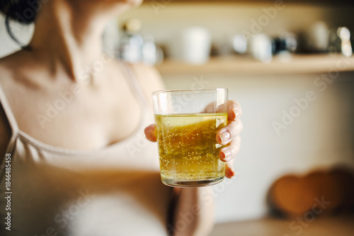 Tableau sur toile Woman holding glass with effervescent supplement drink