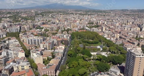 Aerial view of the Giardino Bellini, also known as Villa Bellini (in English: Bellini Garden). It is the oldest urban park in Catania, Sicily, Italy. In the background, Mount Etna looms in silhouette.