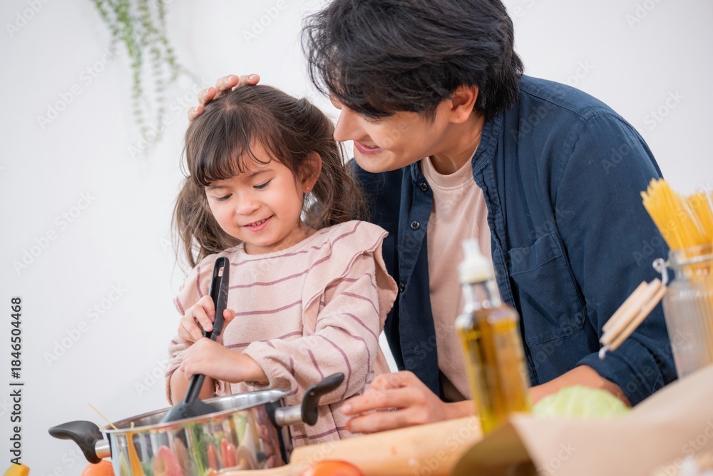 Obraz premium Father and daughter cooking together in a kitchen while stirring a pot of food in the afternoon