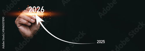 A hand drawing an upward arrow from 2025 to 2026, symbolizing future growth, business progress, strategic planning, success, and positive financial forecast