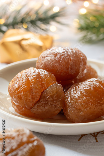 Close up of plate of French tradition candied chestnut or marron glacé with festive decoration and Christmas atmosphere.