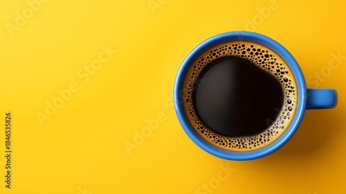 Blue mug filled with warm coffee on yellow background