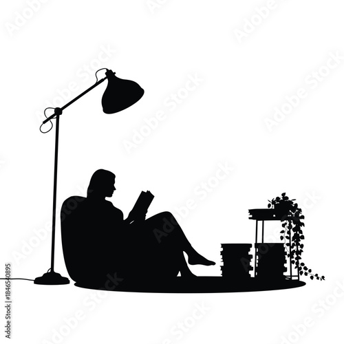 Silhouette of a person reading by a lamp
