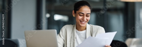 Young hispanic female professional reviewing documents at office desk