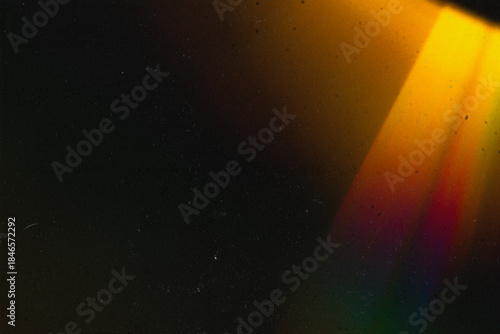 Abstract vintage-style background featuring textured grain, dust, scratches, and soft colorful light effects. Aged analog aesthetics create a dynamic, distressed atmosphere suitable for cinematic and 