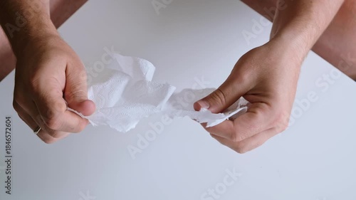 Male hands tearing paper sheet into pieces on white background top view. Concept of problems, frustration, dismissal, destruction, tension in personal settings. Stress relief. High quality 4k footage.