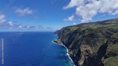 Aerial 4K drone footage of dramatic coastal cliffs and lighthouse viewpoint on Madeira island, overlooking the deep blue Atlantic Ocean and rugged shoreline in clear daylight.