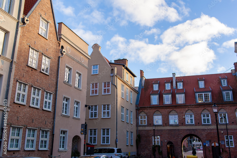 Fototapeta premium Poland. The Cow Gate in the city of Gdansk. Buildings frame an archway connecting to a bridge.