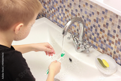 Morning hygiene: A little boy learns to brush his teeth on his own