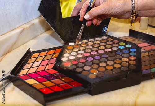 Makeup palette with hand picking eyeshadow using a brush